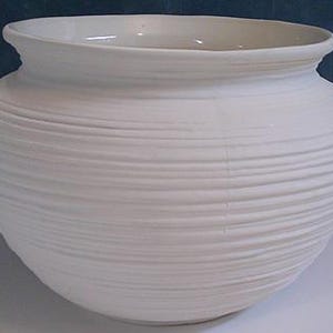 May include: A white ceramic vase with a wide, rounded body and a slightly flared rim. The exterior features horizontal, textured ridges that encircle the entire vessel. The vase is unadorned, showcasing a simple, elegant design suitable for various decorative purposes.
