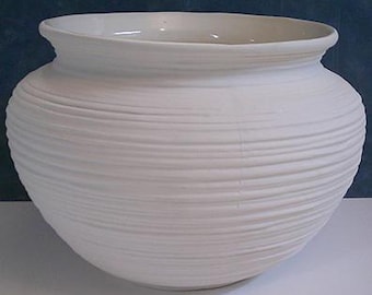 Könnte beinhalten: Eine weiße Keramikvase mit einem breiten, abgerundeten Körper und einem leicht ausgestellten Rand. Die Außenseite weist horizontale, strukturierte Rippen auf, die das gesamte Gefäß umschließen. Die Vase ist schmucklos und zeigt ein schlichtes, elegantes Design.