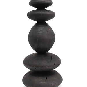 May include: A tall, dark wooden sculpture composed of stacked, rounded shapes. The sculpture has a natural, organic aesthetic, with visible wood grain and a charred finish. The arrangement of the shapes creates a balanced, eye-catching design, suitable for home decor.