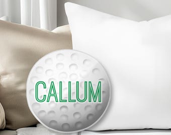 Könnte beinhalten: Ein weißer runder Kissenbezug mit einem grünen Golfball-Design und dem Namen "CALLUM" in grün.
