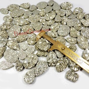 Druzy-cabochon van pyriet. Druzy-geode van gouden pyrietkristal. Natuurlijke pyrietedelsteen. 110 stuks: 5000 kt. Gemengde vorm pyriet druzy groothandel