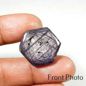 Peut inclure: Une pierre précieuse hexagonale violette avec un motif en forme d'étoile de lignes entrecroisées. La pierre a une surface polie et un aspect légèrement translucide. L'image est intitulée "Front Photo".