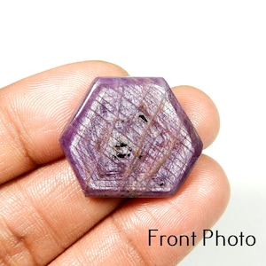 May include: Hexagon-shaped, polished gemstone with a deep purple hue and internal crystalline patterns. The stone has a smooth, reflective surface with subtle variations in color and texture. The image is labeled "Front Photo".