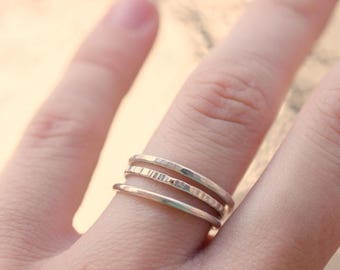 May include: A set of three silver stacking rings with a hammered texture.