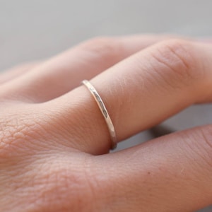 Op de afbeelding: Een eenvoudige, gehamerde zilveren ring gedragen aan een vinger.