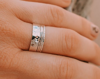 Set of 4 sterling silver rings, a band ring and three skinny rings