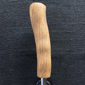 May include: A wooden beer tap handle with a natural wood grain finish and a chrome tap spout.