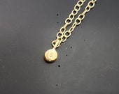Solid gold tiny letter pebble pendant, a teeny tiny recycled 9ct gold personalised initial stacking handmade circle charm necklace gold blob