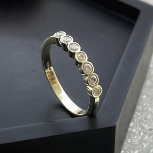 7 sparkly diamonds in a row set in a 9ct yellow gold modern eternity ring