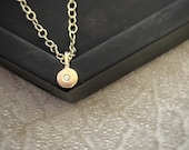 Solid gold tiny pebble diamond pendant, small recycled 9ct gold circle set with a simple modern round sparkly diamond on a gold chain