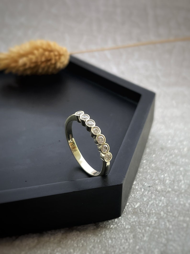 7 sparkly diamonds in a row set in a 9ct yellow gold modern eternity ring
