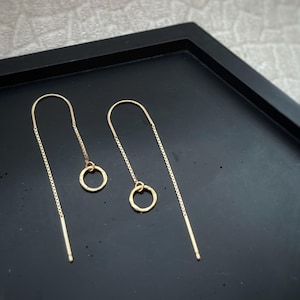 Puede incluir: Un par de pendientes de aro dorados con un círculo martillado en cada pendiente.