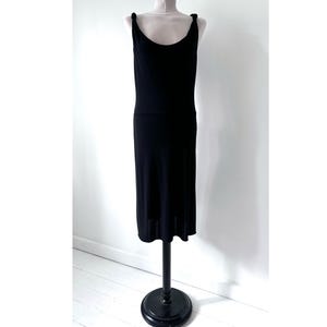 May include: A black sleeveless midi dress with a scoop neck and knotted straps.