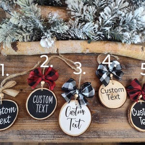 May include: Five round wood ornaments with black and white, red and black, and brown and tan ribbon bows. Each ornament has a black or white background with the text "Custom Text" written in white or black.
