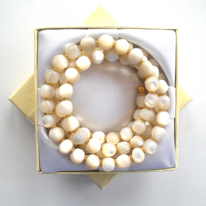 This unique handmade memory wire bracelet has more than 90 white mother of pearl beads interspersed with tiny gold plated spacer beads.  It is finished with gold plated end caps. It will fit any size of wrist, with four to five circles in total.