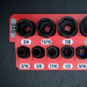 May include: A red socket organizer with black sockets of various sizes. The organizer is labeled "SAE" and "3/8 DRIVE". Sockets are labeled with sizes from 5/16 to 1 inch.