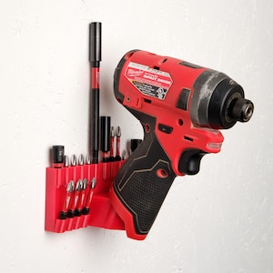 May include: A red and black cordless impact driver with a black and red bit holder attached to a white wall. The bit holder has a variety of different sized drill bits.
