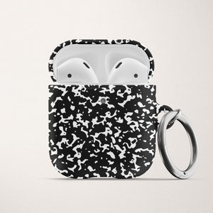 May include: A black and white notebook paper patterned case for AirPods with a silver ring attached.