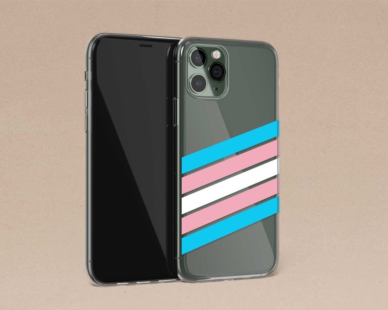 May include: A clear phone case with a transgender pride flag design. The case is on a brown background.