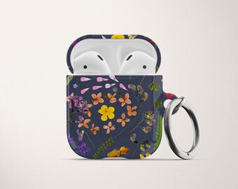 May include: A blue and white floral patterned case for wireless earbuds with a silver metal ring attached.