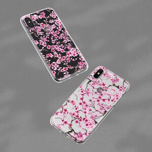 Puede incluir: Dos fundas transparentes para tel&eacute;fono con un dise&ntilde;o floral rosa y blanco. Las fundas est&aacute;n hechas de pl&aacute;stico transparente y tienen un patr&oacute;n floral impreso en la parte posterior.