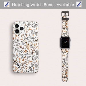 May include: A white phone case and matching watch band with a floral pattern in shades of brown and black. The text "Matching Watch Bands Available" is at the top of the image.