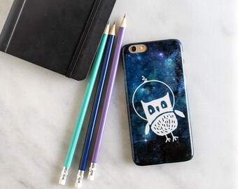 May include: A galaxy-themed phone case with a white owl design. The owl is in a circle with a star above it. The background is a dark blue with white stars.