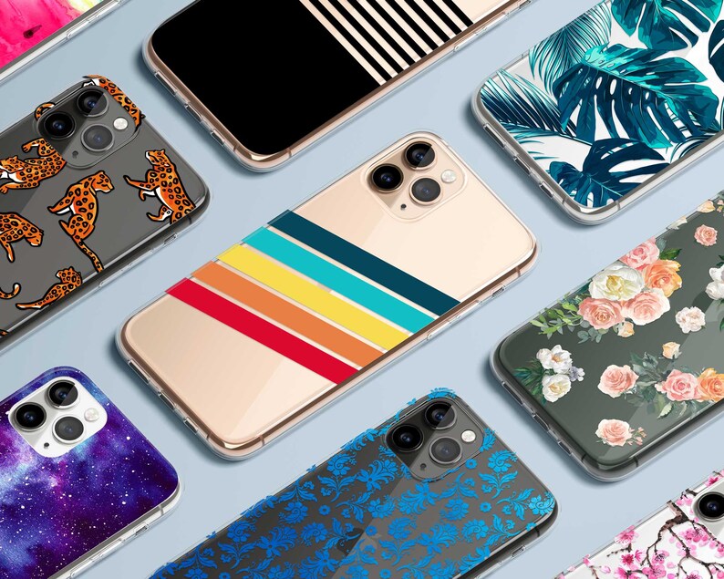 K&ouml;nnte beinhalten: Sortiment an bunten Handyh&uuml;llen mit verschiedenen Designs, darunter ein Galaxie-Druck, ein tropisches Blatt-Muster, ein Blumenmuster und ein Regenbogenstreifen-Muster.