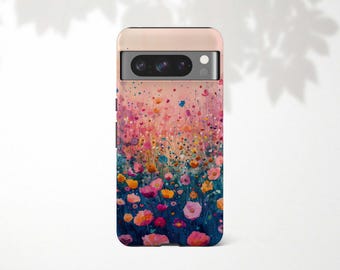 May include: A phone case with a floral design. The case features a colorful watercolor painting of wildflowers in shades of pink, yellow, and blue against a gradient background. The phone case has a light pink top.