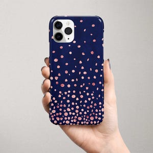 Może przedstawiać: Etui na telefon w kolorze granatowym z wzorem różowych konfetti. Etui jest przeznaczone do telefonu iPhone.