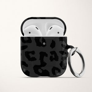 May include: Black and white leopard print Airpods case with a silver keychain.