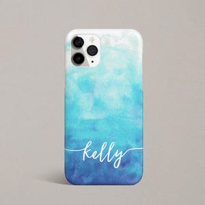 Może przedstawiać: Etui na telefon w kolorze niebieskim i białym z akwarelowym wzorem, z imieniem "kelly" napisanym białym, ozdobnym pismem.