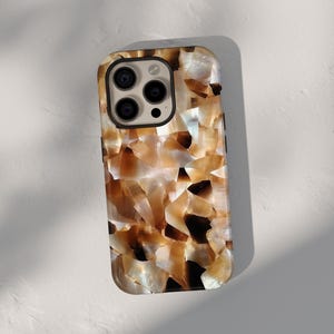 May include: A brown and white iPhone case with a unique, textured design that resembles a natural stone or shell pattern. The case has a raised camera bump and a black border.