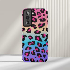May include: A phone case with a colorful ombre leopard print design. The case has a black camera cutout and a black border.