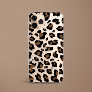 May include: A clear phone case with a brown and black leopard print design. The case has a cutout for the phone's camera.
