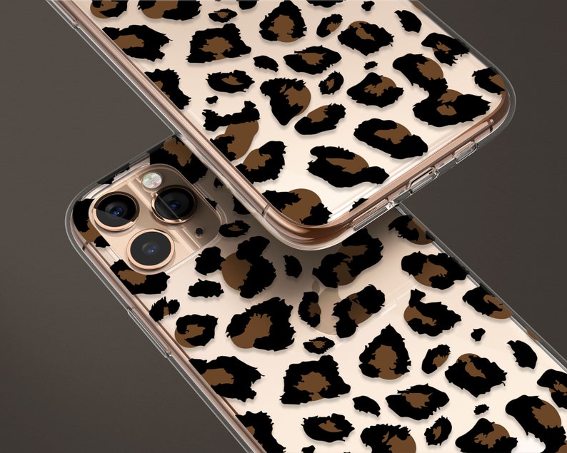 May include: Two clear phone cases with a leopard print design. The case on top has a gold trim. The case on the bottom has a camera cutout.