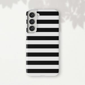 May include: A black and white striped phone case with a triple lens camera cutout.