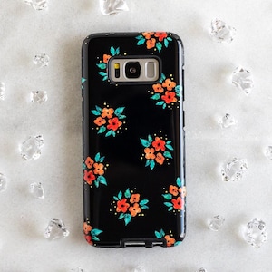 May include: Black phone case with a floral pattern featuring orange, red, and green flowers on a black background.