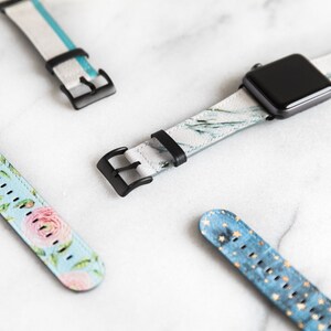 Puede incluir: Cuatro correas diferentes para Apple Watch con varios patrones. Las correas son blancas con detalles azules, florales, de m&aacute;rmol y azules con estrellas doradas.