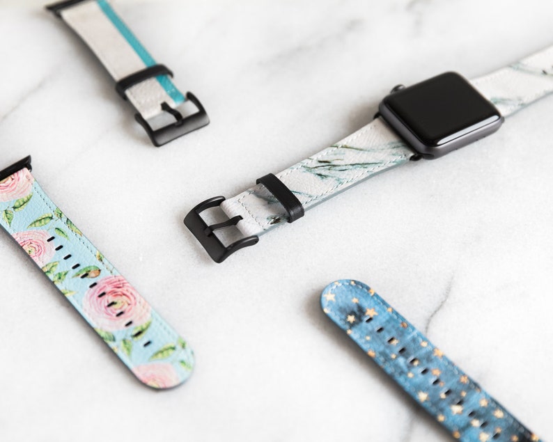 Puede incluir: Cuatro correas diferentes para Apple Watch con varios patrones. Las correas son blancas con detalles azules, florales, de m&aacute;rmol y azules con estrellas doradas.