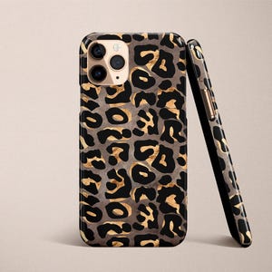 May include: A black and gold leopard print phone case for an iPhone.