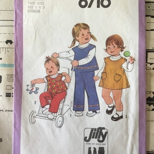 May include: Simplicity sewing pattern number 8716 for toddler-sized clothing. The pattern includes instructions for a blue and white vest, pants, and a brown dress. The pattern is labeled "Jiffy" and includes 2 or 3 main pattern pieces.