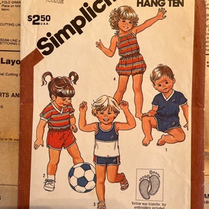 May include: A Simplicity sewing pattern for children's clothing, featuring three designs for girls and boys. The pattern is for sizes 1-4 toddler and includes a yellow wax transfer for embroidery. The pattern is titled "Hang Ten" and is for stretch knits only. The pattern is number 5953.