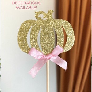 May include: Gold glitter pumpkin cake topper with a pink bow.  Matching decorations available.