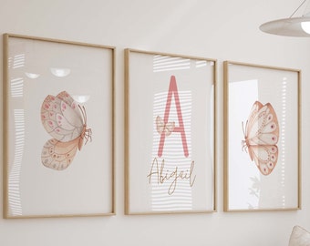May include: Three framed prints with a watercolor butterfly design. The center print features the letter "A" in pink with the name "Abigail" written below it.