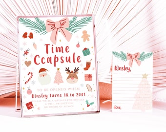 Puede incluir: Una cápsula del tiempo rosa y blanca con temática navideña. La parte delantera de la cápsula tiene un lazo rosa, un árbol de Navidad, un reno y Papá Noel. El texto en la parte delantera dice "Time Capsule" y "To be opened when Kinsley turns 18 in 2041. Please write a message for Kinsley, a wish, prediction, or words of advice."