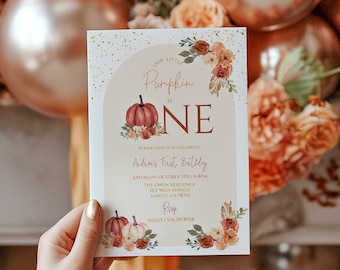 May include: A fall-themed first birthday invitation with a pumpkin and the words "Our Little Pumpkin is One". The invitation is decorated with floral accents and gold glitter.