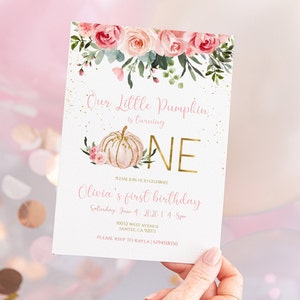 May include: A pink and gold first birthday invitation with a watercolor pumpkin and floral design. The text reads "Our Little Pumpkin is turning ONE. Please join us to celebrate Olivia's first birthday. Saturday, June 4, 2020 1-4 pm. 10032 West Avenue, Santee, CA 92071. Please RSVP to Kayla | 6194518350"