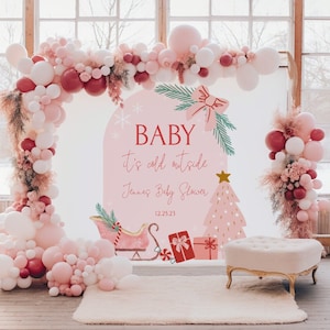 May include: A pink and white balloon arch with a pink and green baby shower sign that says "Baby it's cold outside Jenna's Baby Shower 12.25.23". The sign also features a pink Christmas tree, a sleigh, and presents.