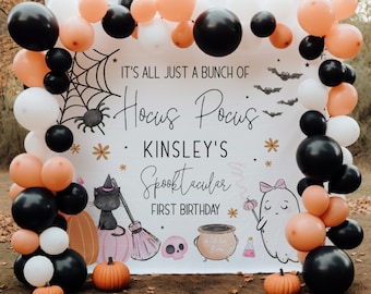 May include: A white backdrop with black and orange balloons, a black spider web, and a sign that reads "It's all just a bunch of Hocus Pocus * Kinsley's Spooktacular First Birthday *" with a black cat and a ghost illustration.